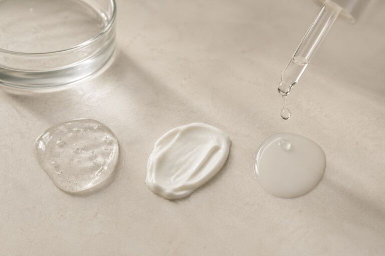 Wirkstoffe kombinieren empfindliche Haut – Drei Skincare-Wirkstoffe für empfindliche Haut als Texturen: Hyaluronsäure, Niacinamid und beruhigende Creme auf neutralem Hintergrund